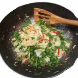 fried cabbage in a sauce pan and a wooden spatula